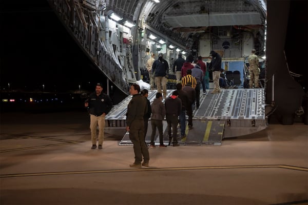 This photo provided by the U.S. Dept. of Defense, U.S. Customs and Border Protection agents guide undocumented immigrants onto a C-17 Globemaster III at the Tucson International Airport, Ariz., Thursday, Jan. 23, 2025. (TSgt Kimberly Nagle/U.S. Dept. of Defense via AP)