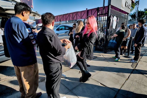 An Sabrina Bratt, movie fan receives her tee-shirts during a merchandise Pop-Up event for the newly released movie Anora on Saturday, Nov. 9, 2024 in Los Angeles. (AP Photo/Richard Vogel)