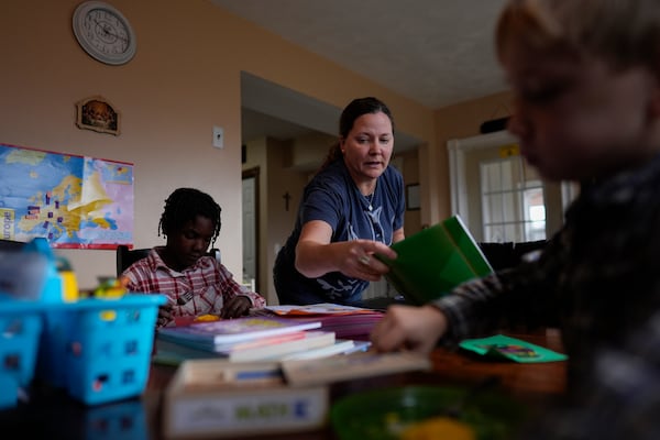 Erin Young homeschools her adopted children, Isaac, 5, right, and Gianna, 7, left, in the dining room of their Sunbury, Ohio, home on Tuesday, Nov. 12, 2024. (AP Photo/Carolyn Kaster)