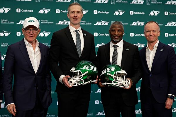 New York Jets owner Woody Johnson, left, and vice chairman Christopher Johnson, right, pose for a photo with new head coach Aaron Glenn, second right, and general manager Darren Mougey during a press conference at the NFL football team's training facility on Monday, Jan. 27, 2025, in Florham Park, N.J. (AP Photo/Adam Hunger)