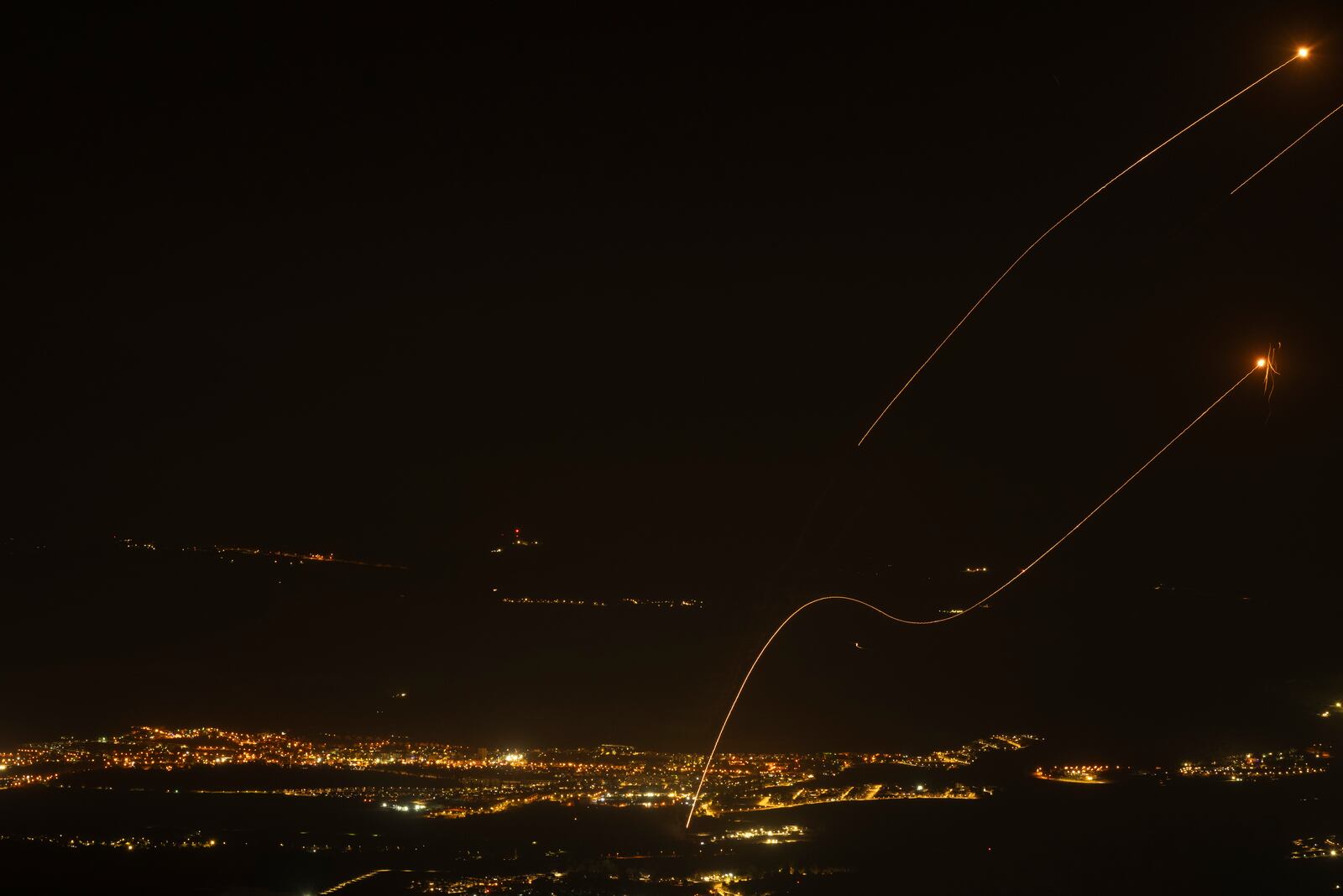 The Israeli Iron Dome air defense system fires to intercept rockets launched from Lebanon, near Kiryat Shmona, as seen from the Israeli-annexed Golan Heights, Saturday, Oct. 26, 2024. (AP Photo/Leo Correa)