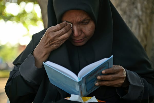 A woman weeps as she prays at a mass grave at victims of the 2004 Indian Ocean tsunami, in Banda Aceh, Indonesia, Thursday, Dec. 26, 2024. (AP Photo/Reza Saifullah)