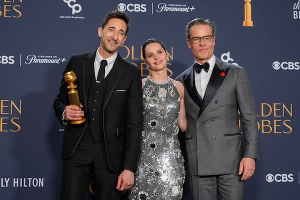 Adrien Brody, winner of the award for best performance by a male actor in a motion picture drama for "The Brutalist", from left, Felicity Jones, and Guy Pearce pose in the press room during the 82nd Golden Globes on Sunday, Jan. 5, 2025, at the Beverly Hilton in Beverly Hills, Calif. (AP Photo/Chris Pizzello)