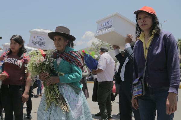 People carry the remains of relatives who were killed during Peru's internal armed conflict (1980-2000) to a cemetery after a Mass at the Cathedral in Ayacucho, Peru, Wednesday, Oct. 23, 2024, the day the remains were returned. (AP Photo/Silvio La Rosa)