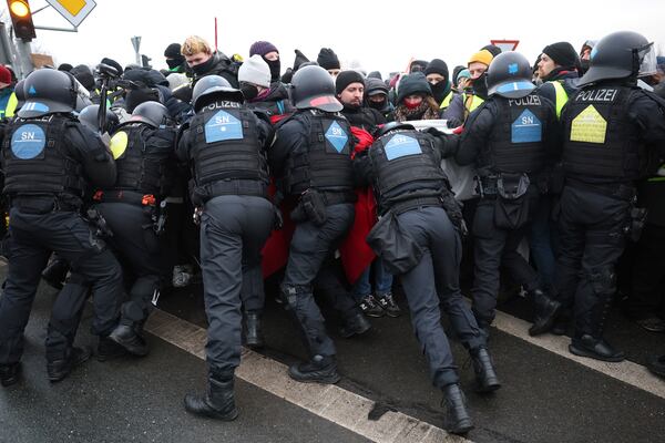 Police officers react with protestors to stop a demonstration against the AfD's national party conference, in Riesa, Germany, Saturday, Jan. 11, 2025. (Jan Woitas/dpa via AP)