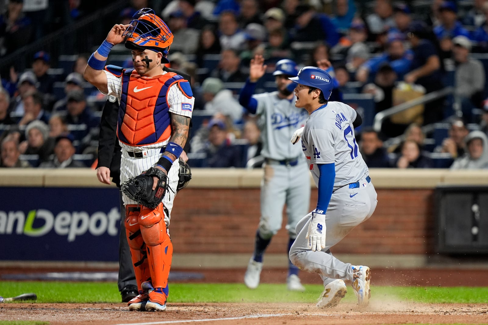 Los Angeles Dodgers' Shohei Ohtani scores past New York Mets catcher Francisco Alvarez on a double by Mookie Betts during the fourth inning in Game 4 of a baseball NL Championship Series, Thursday, Oct. 17, 2024, in New York. (AP Photo/Frank Franklin II)