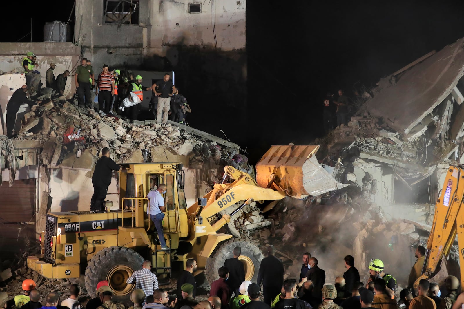 Rescue workers use a bulldozer to remove rubbles as they search for victims at a destroyed building hit in an Israeli airstrike, in the southern port city of Sidon, Lebanon, Tuesday, Oct. 29, 2024. (AP Photo/Mohammed Zaatari)