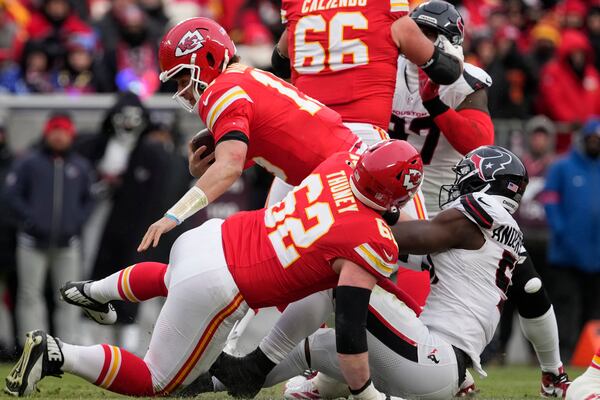 Kansas City Chiefs quarterback Patrick Mahomes (15) is sacked by Houston Texans defensive end Will Anderson Jr., right, as Chiefs guard Joe Thuney (62) assists during the first half of an NFL football AFC divisional playoff game Saturday, Jan. 18, 2025, in Kansas City, Mo. (AP Photo/Ed Zurga)