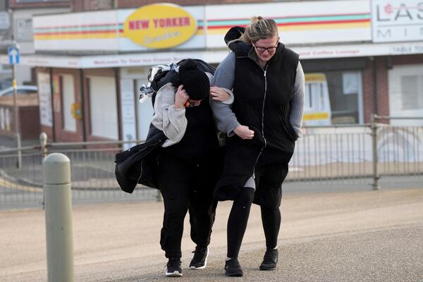 Two women brave the wind as Storm Eowyn hits the country in Cleveleys, near Blackpool, England, Friday, Jan. 24, 2025.(AP Photo/Jon Super)