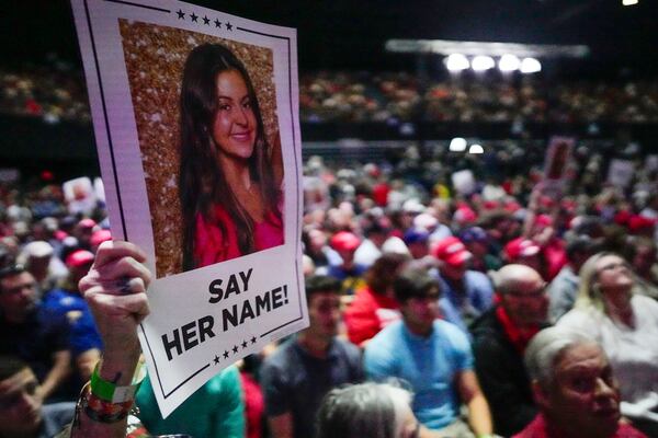 FILE - A supporter holds a poster with a photo of Laken Riley before Republican presidential candidate former President Donald Trump speaks at a campaign rally March 9, 2024, in Rome Ga. (AP Photo/Mike Stewart, File)