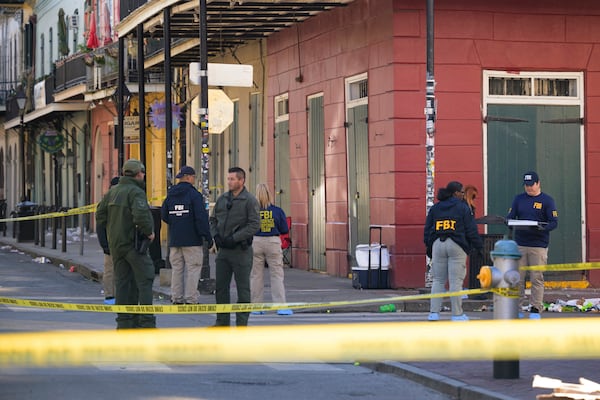 The FBI investigates the area on Orleans St and Bourbon Street by St. Louis Cathedral in the French Quarter where a suspicious package was detonated after a person drove a truck into a crowd earlier on Bourbon Street on Wednesday, Jan. 1, 2025. (AP Photo/Matthew Hinton)