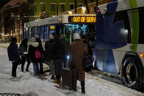 People board a bus to an overnight shelter during a winter storm, Monday, Jan. 6, 2025, in Cincinnati. (AP Photo/Joshua A. Bickel)