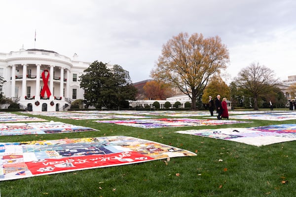 President Joe Biden and first lady Jill Biden walk between AIDS Memorial Quilts spread over the South Lawn of the White House during a ceremony to commemorate World AIDS Day with survivors, their families and advocates, Sunday, Dec. 1, 2024, in Washington. (AP Photo/Manuel Balce Ceneta)