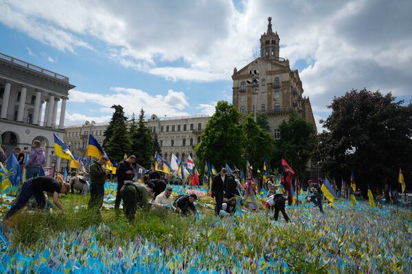 Volunteers put in order the site of an improvised memorial to fallen soldiers on Independence Square in Kyiv, Ukraine, Wednesday, May 15, 2024. (AP Photo/Efrem Lukatsky)