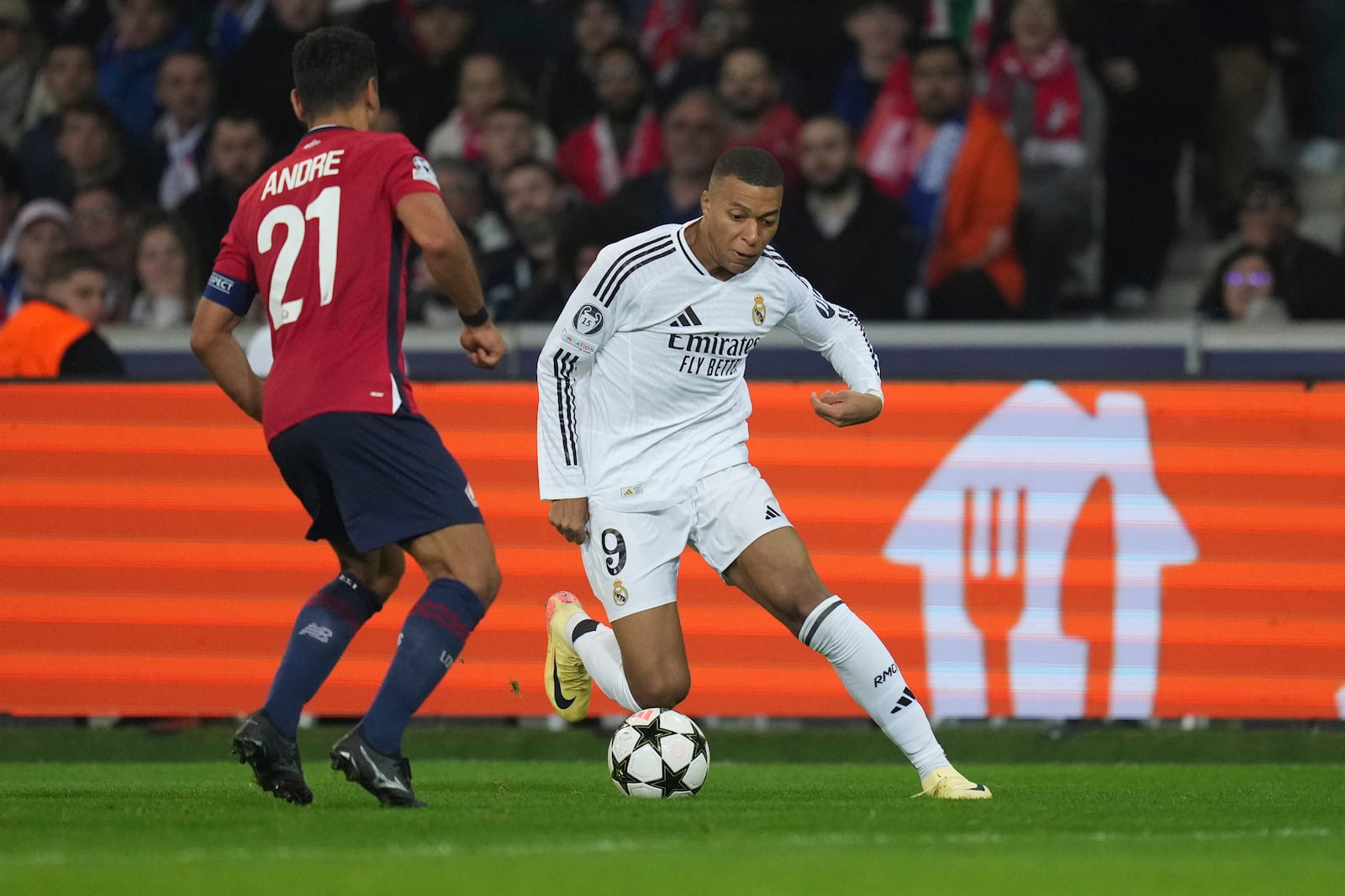 Real Madrid's Kylian Mbappe, right, dribbles the ball past Lille's Benjamin Andre during the Champions League opening phase soccer match between Lille and Real Madrid at the Stade Pierre Mauroy in Villeneuve-d'Ascq, outside Lille, France, Wednesday, Oct. 2, 2024. (AP Photo/Thibault Camus)