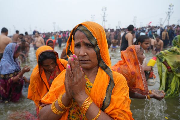 Hindu devotees pray after taking a holy dip in the Sangam, the confluence of the Ganges, the Yamuna and the mythical Saraswati rivers, on "Mauni Amavasya" or new moon day during the Maha Kumbh festival in Prayagraj, India, Wednesday, Jan. 29, 2025. (AP Photo/Deepak Sharma)