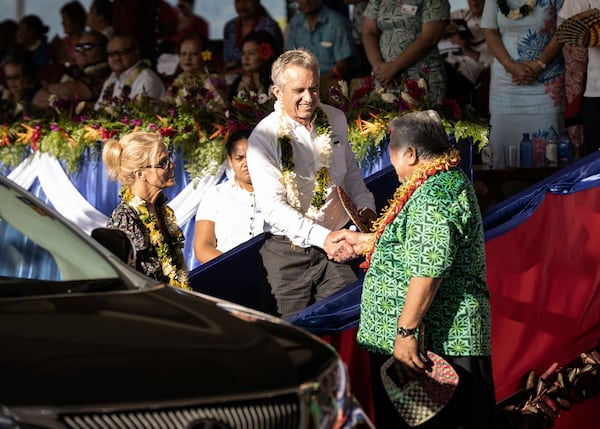 FILE - Prime Minister Tuilaepa Sailele Malielegaoi, foreground right, shakes hands with Robert F. Kennedy Jr. before he left the the 57th Independence Celebration in Mulinu'u, Samoa, on June 1, 2019. At foreground left is Kennedy's wife, actress Cheryl Hines. Kennedy said the trip was arranged by Edwin Tamasese, a local anti-vaccine influencer. (Misiona Simo/Samoa Observer via AP, File)