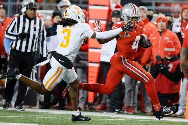 Ohio State receiver Jeremiah Smith, right, stiff-arms Tennessee defensive back Jermod McCoy, left, during the first half in the first round of the College Football Playoff, Saturday, Dec. 21, 2024, in Columbus, Ohio. (AP Photo/Jay LaPrete)