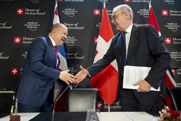 Thailand's Minister of Commerce Pichai, left, shake hands with Switzerland's Economy Minister Federal Councillor Guy Parmelin during the signing Ceremony of the Free Trade Agreement between the EFTA States and the Kingdom of Thailand at the House of Switzerland, during the World Economic Forum, WEF, in Davos, Switzerland, Thursday, January 23, 2025. (Laurent Gillieron/Keystone via AP)