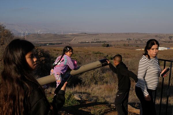 A girl plays atop a tank on display near the Syrian side of the Quneitra crossing, between Israel and Syria, as seen from the Israeli-occupied Golan Heights, Saturday, Dec. 14, 2024. (AP Photo/Matias Delacroix)