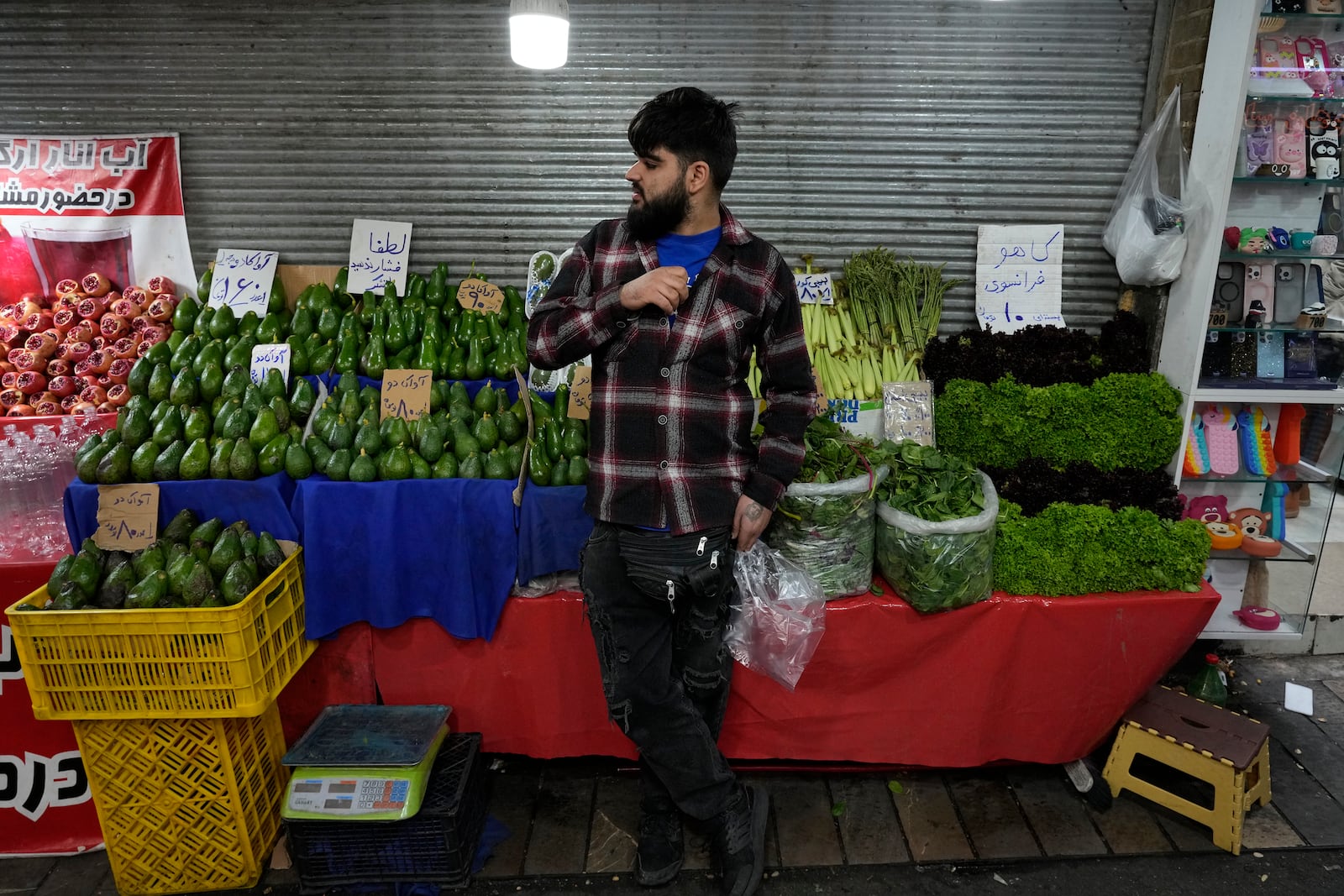 A grocery seller waits for customers at Tajrish traditional bazaar in northern Tehran, Iran, Saturday, Oct. 26, 2024. (AP Photo/Vahid Salemi)