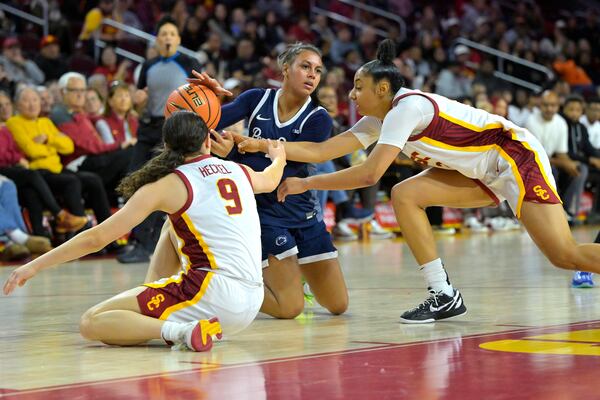 Southern California guard Kayleigh Heckel (9), Southern California guard JuJu Watkins, right, and Penn State guard Shaelyn Steele, center, battle for the ball during the second half of an NCAA college basketball game Sunday, Jan. 12, 2025, in Los Angeles. (AP Photo/Jayne Kamin-Oncea)