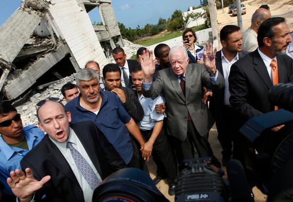 FILE - Former President Jimmy Carter, center, speaks to the media at the ruins of the American International School, which was destroyed during Israel's offensive in Gaza, in Beit Lahiya, northern Gaza Strip, June 16, 2009. Carter says he's trying to persuade Hamas leaders to accept the international community's conditions for ending its boycott of the Islamic militant group. (AP Photo/Khalil Hamra, File)