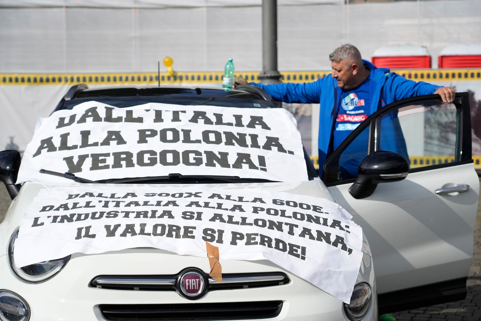 A banner reading "From Italy to Poland, shame!" is placed on a car during a demonstration of workers of automotive sector in Rome's Piazza Del Popolo Square on the occasion of their national strike, Friday, Oct. 18, 2024. (AP Photo/Gregorio Borgia)