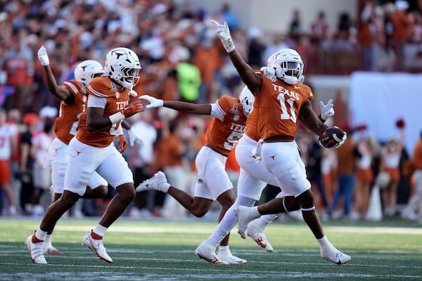 Texas linebacker Colin Simmons (11) celebrates with teammates after an interception during the first half against Clemson in the first round of the College Football Playoff, Saturday, Dec. 21, 2024, in Austin, Texas. (AP Photo/Eric Gay)