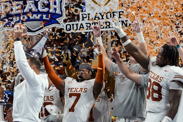 Texas players celebrate victory after a quarterfinals College Football Playoff game against Arizona State, Wednesday, Jan. 1, 2025, in Atlanta. Texas won 39-31 in two overtime periods. (AP Photo/John Bazemore)