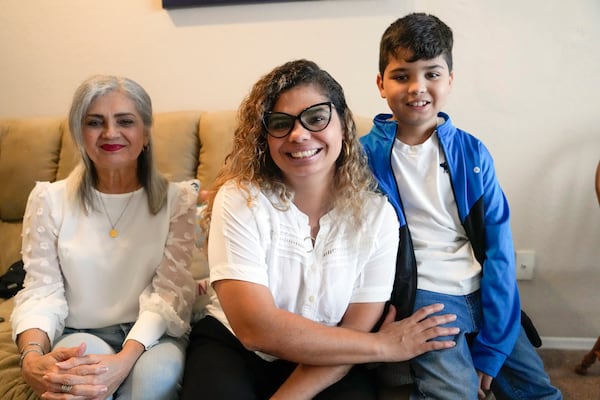 FILE - Caren Anez, center, with her 10-year-old son Lucas Tello, right, and her mother, Carmen Valbuena, pose for a picture at her apartment, Sept. 27, 2023, in Orlando, Florida. (AP Photo/John Raoux, File)