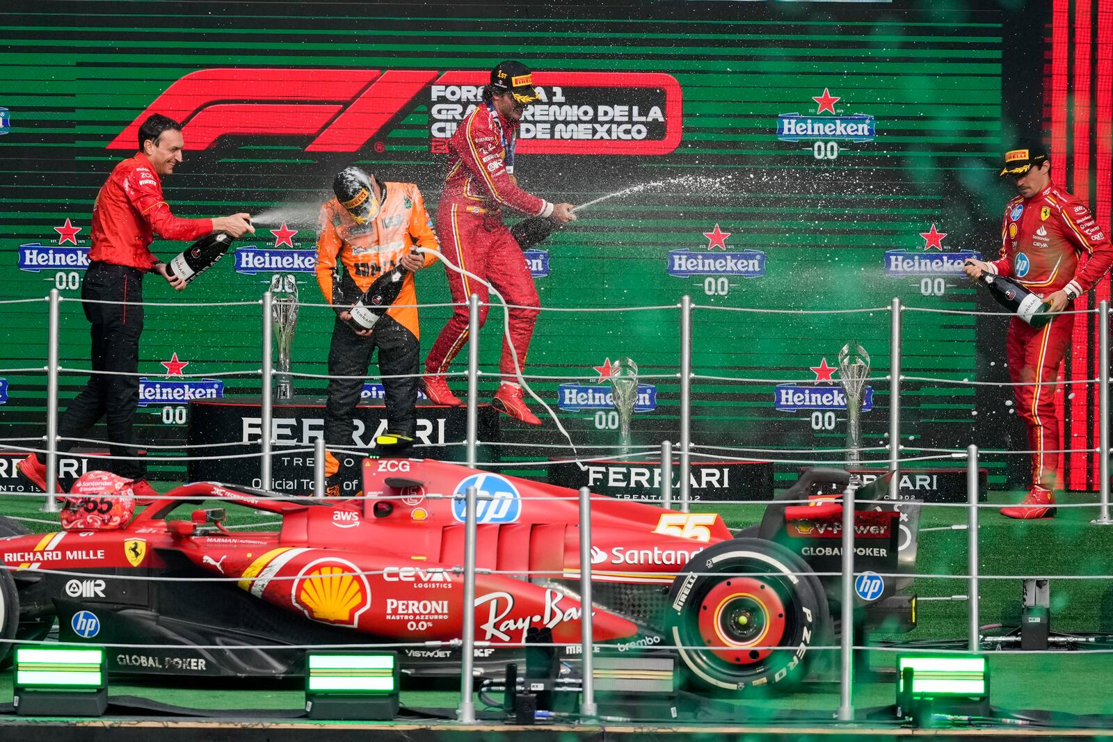 Ferrari driver Carlos Sainz of Spain, first place, center, Charles Leclerc of Monaco, third place, right, Riccardo Adami of Ferrari, left, and McLaren driver Lando Norris of Britain, second place, celebrate at the podium for the Formula One Mexico Grand Prix auto race at the Hermanos Rodriguez racetrack in Mexico City, Sunday, Oct. 27, 2024. (AP Photo/Eduardo Verdugo)