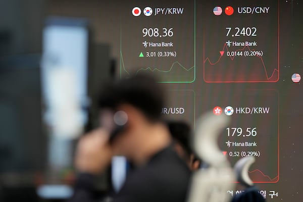 A currency trader talks on the phone near the screens showing the foreign exchange rates at a foreign exchange dealing room in Seoul, South Korea, Monday, Nov. 25, 2024. (AP Photo/Lee Jin-man)