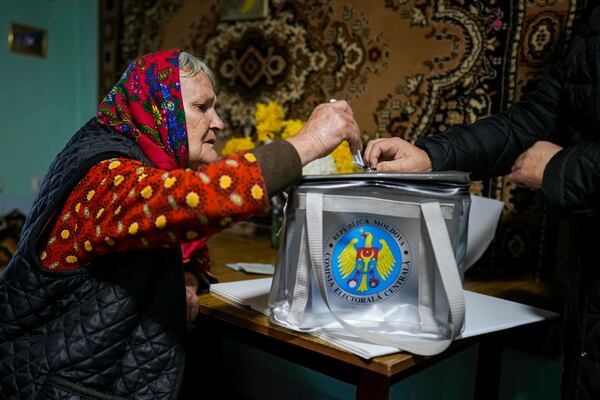 A woman casts her vote in a mobile ballot box during a presidential election runoff, in the village of Ciopleni, Moldova, Sunday, Nov. 3, 2024. (AP Photo/Vadim Ghirda)