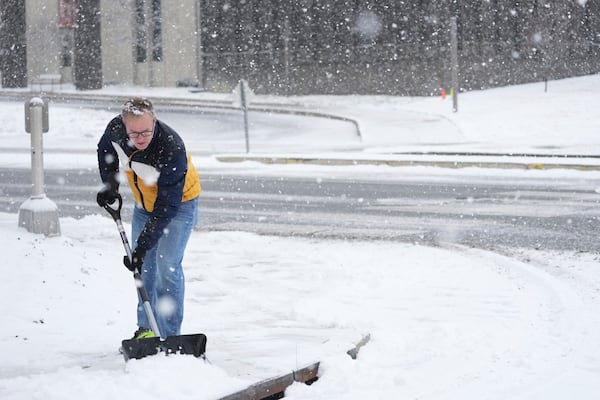 Chris Ashton shovels snow Friday, Jan 10, 2025, in Nashville, Tenn. (AP Photo/George Walker IV)