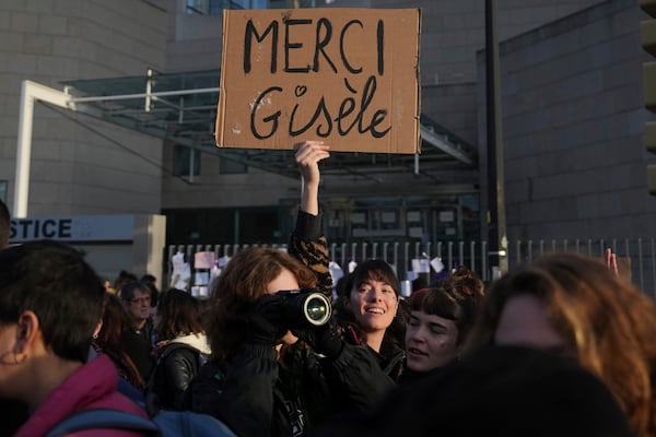 FILE - A woman holds a placard that reads, "Thank you Gisele," outside the Palace of Justice during a women's rights demonstration, Dec. 14, 2024, in Avignon, southern France, where dozens of men are on trial in Avignon, accused of raping Gisèle Pelicot while she was drugged and rendered unconscious by her husband. (AP Photo/Aurelien Morissard, File)