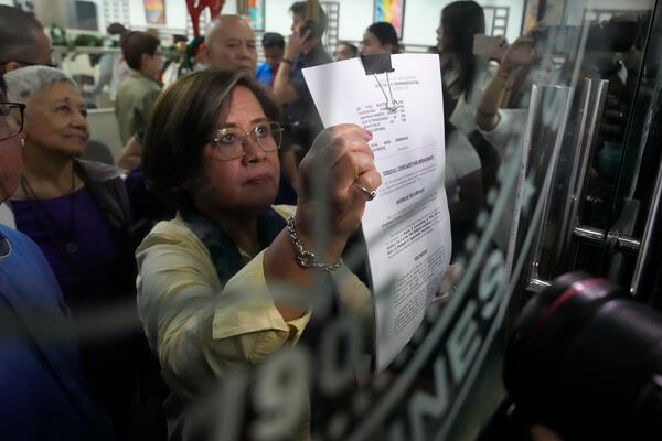 Former Senator Leila de Lima shows an impeachment complaint which they will file against Philippine Vice President Sara Duterte as they wait for the secretary general to receive it at the House of Representatives in Quezon City, Philippines on Monday, Dec. 2, 2024. (AP Photo/Aaron Favila)