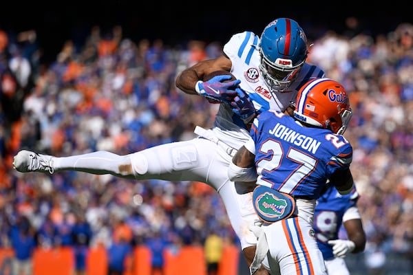 Mississippi wide receiver Tre Harris (9) is hit by Florida defensive back Dijon Johnson (27), forcing an incomplete pass during the first half of an NCAA college football game, Saturday, Nov. 23, 2024, in Gainesville, Fla. (AP Photo/Phelan M. Ebenhack)