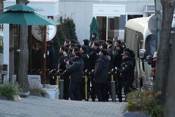 Police officers arrive at the gate of the presidential residence as supporters of impeached South Korean President Yoon Suk Yeol stage a rally to oppose a court having issued a warrant to detain Yoon, in Seoul, South Korea, Friday, Jan. 3, 2025. (AP Photo/Lee Jin-man)