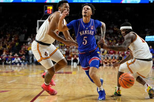 Kansas guard Zeke Mayo (5) loses control of the ball as he drives between Iowa State forward Joshua Jefferson, left, and guard Keshon Gilbert, right, during the first half of an NCAA college basketball game Wednesday, Jan. 15, 2025, in Ames, Iowa. (AP Photo/Charlie Neibergall)