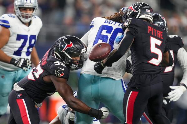 Houston Texans defensive end Dylan Horton, left, forces Dallas Cowboys offensive tackle Tyler Guyton, center, to fumble the ball during the second half of an NFL football game, Monday, Nov. 18, 2024, in Arlington, Texas. (AP Photo/Tony Gutierrez)