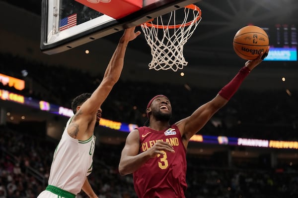 Cleveland Cavaliers guard Caris LeVert (3) shoots in front of Boston Celtics forward Jayson Tatum, left, in the first half of an NBA basketball game, Sunday, Dec. 1, 2024, in Cleveland. (AP Photo/Sue Ogrocki)