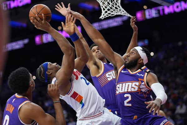 Philadelphia 76ers' Guerschon Yabusele, center, goes up for a shot against Phoenix Suns' Ryan Dunn, from left, Oso Ighodaro and Josh Okogie during the first half of an NBA basketball game, Monday, Jan. 6, 2025, in Philadelphia. (AP Photo/Matt Slocum)