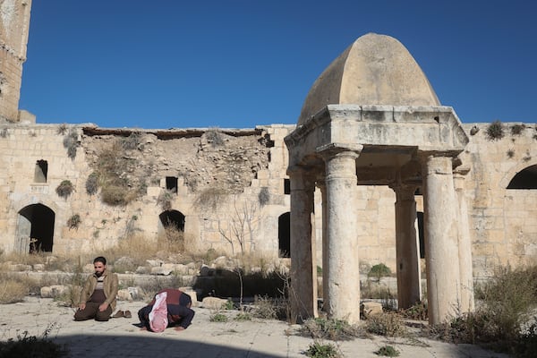 Two men pray at the 12th-century landmark Grand Mosque of Maarat al-Numan, southwest of Aleppo, Sunday, Dec. 1, 2024. Syrian opposition insurgency launched a campaign on Wednesday with a two-pronged attack on Aleppo and the countryside around Idlib.(AP Photo/Ghaith Alsayed)