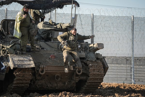 An Israeli soldier jumps off an armoured vehicle at a staging area near the Gaza border in southern Israel, Thursday Jan. 2, 2025. (AP Photo/Tsafrir Abayov))