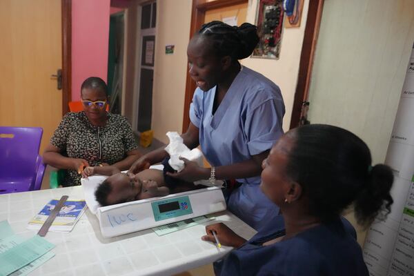 A child is weighed on a scale before he is administered the malaria vaccine R21/Matrix-M at the Health Centre in Yenagoa, Nigeria, Tuesday, Dec. 10, 2024. (AP Photo/Sunday Alamba)