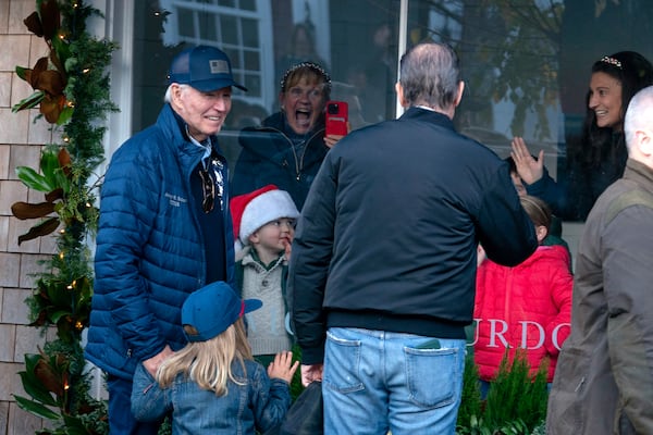 President Joe Biden, from left, accompanied by his grandson Beau Biden and son Hunter Biden, greets people as he walks by a store in downtown Nantucket Mass., Friday, Nov. 29, 2024. (AP Photo/Jose Luis Magana)