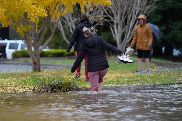 Pedestrians cross a flooded street during a storm Thursday, Nov. 21, 2024, in Santa Rosa, Calif. (AP Photo/Jeff Chiu)