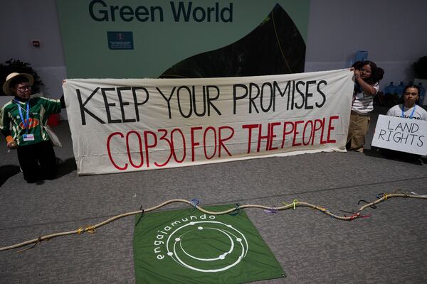 People demonstrate with a sign that reads "keep your promises COP39 for the people" at the COP29 U.N. Climate Summit, Saturday, Nov. 16, 2024, in Baku, Azerbaijan. (AP Photo/Peter Dejong)