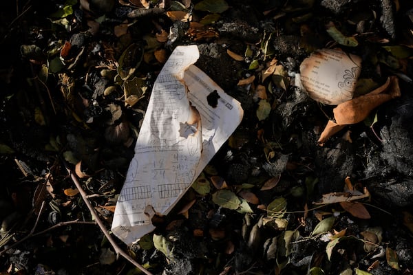 FILE - Burnt school worksheets are seen on the ground outside of an elementary school destroyed by the Eaton Fire, Thursday, Jan. 16, 2025, in Altadena, Calif. (AP Photo/Carolyn Kaster, File)